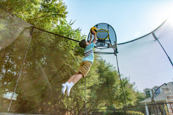 Kluk háže balón na Springfree FlexrHoop.